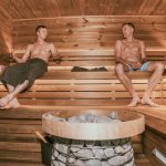 Two men enjoying a relaxing spa experience in a stylish Nordic-designed sauna.
